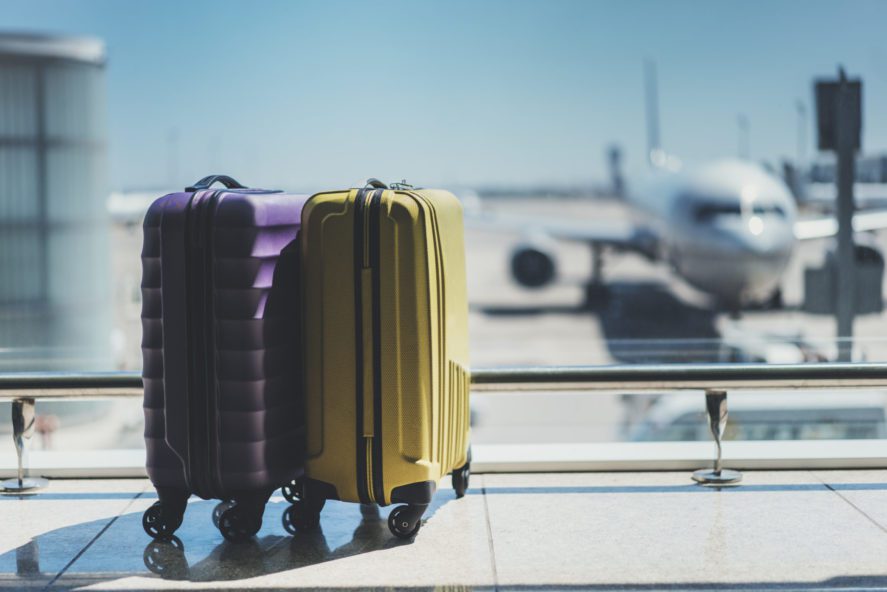 Suitcases,In,Airport,Departure,Lounge,,Airplane,In,Background,,Summer,Vacation - 92.5 The Beat